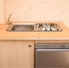 Küche mit Spüle, Wasserhahn, Kochfeld, Geschirrspüler und zusätzlichem Stauraum